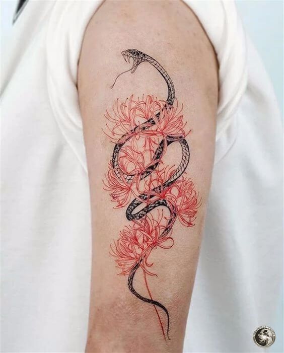 Tatuaje de serpiente en tinta negra entrelazada en plantas de color rojo en la zona del antebrazo