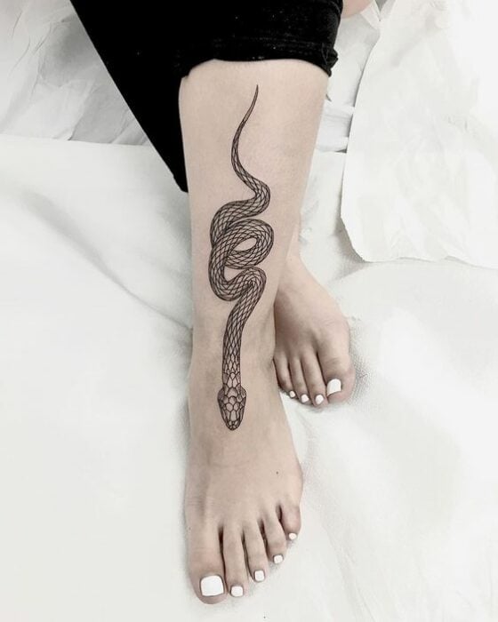 Tatuaje de serpiente en tinta negra sobre la pantorilla y el tobillo