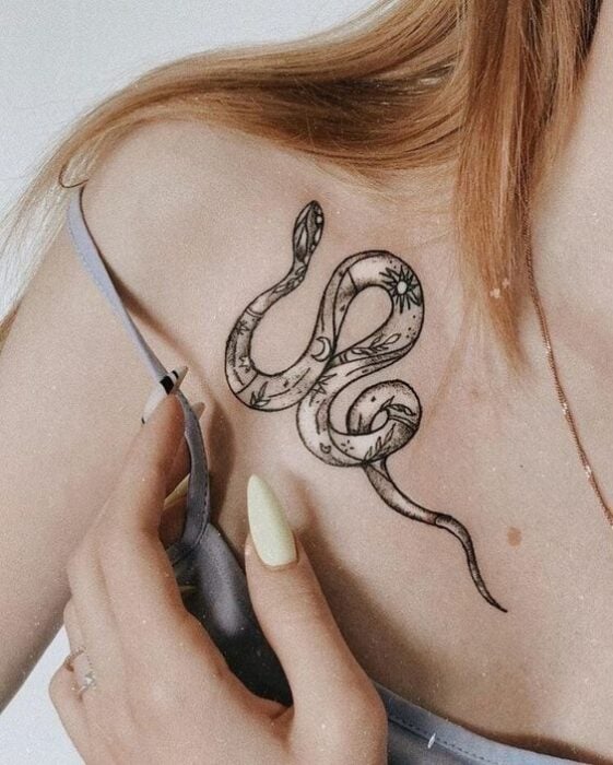 Tatuaje de serpiente en tinta negra sobre la clavícula