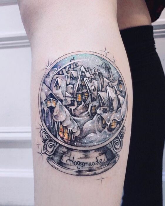 Chica con tatuaje de bola de cristal inspirada en Harry Potter; Tatuajes miniatura para las que aman la Navidad