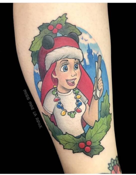 Chica con tatuaje de Ariel celebrando Navidad; Tatuajes para las chicas que aman Navidad