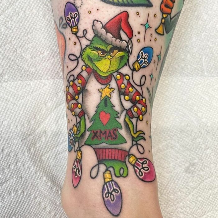 Chica con tatuaje de el Grinch; Tatuajes miniatura para las que aman la Navidad