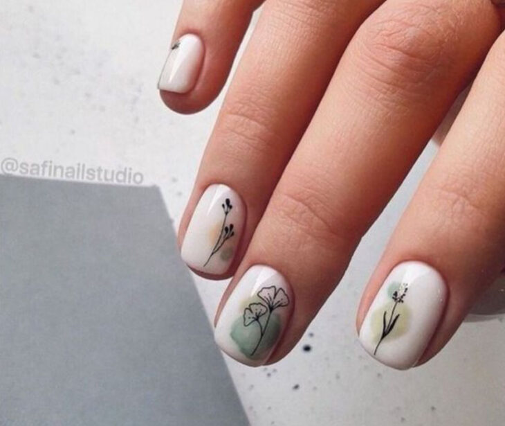 Manicura en color blanco con detalles de flores a mano alzada