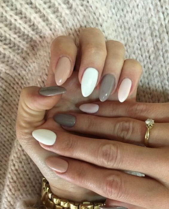 Manicura de diferentes colores, como rosa bebé, blanco y gris