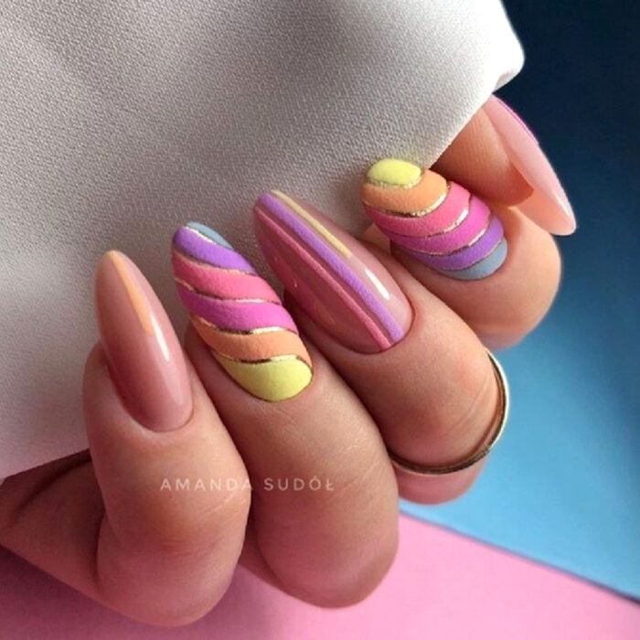 Diseños bonitos de manicura coloridos; manos de mujer con uñas largas en forma de almendra pintadas con esmalte nude rosa y con textura de peluche, terciopelo, amarillo, anaranjado, rosa, morado y azul