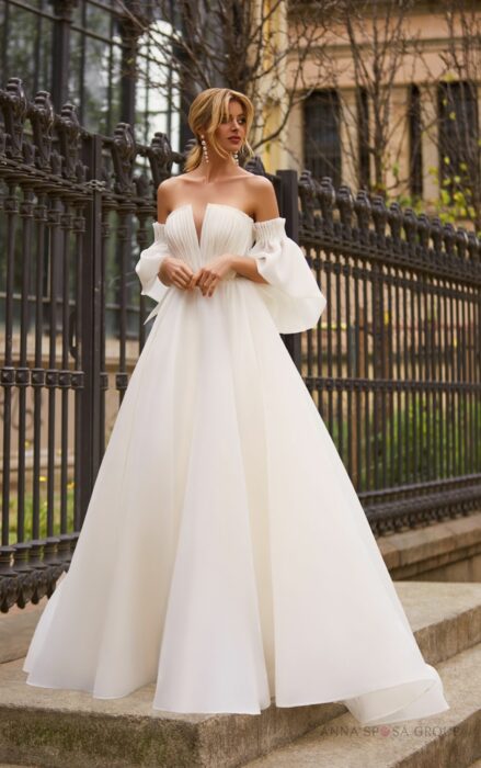 Chica con un vestido de color blanco con falda ancha y unas mangas bombachas 