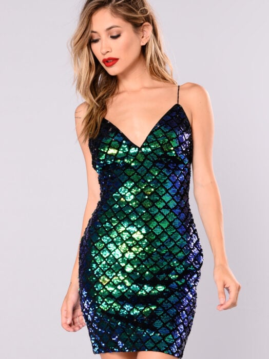 Vestido iridiscente, holográfico con diseño de sirena, de tirantes, mujer rubia de cabello mediano y despeinado