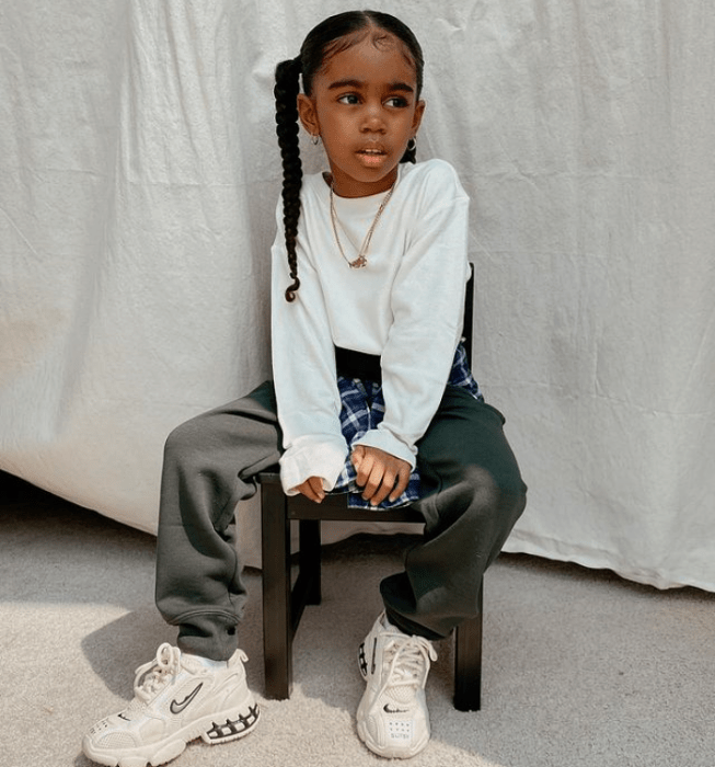 niña morena con cabello largo usando una sudadera blanca, pants color verde militar, tenis blancos