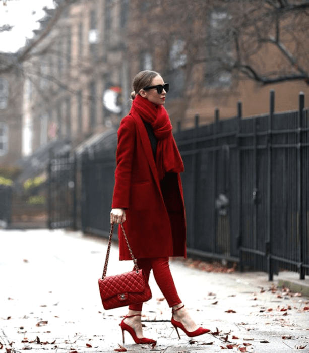 chica de cabello claro usando lentes de sol, bufanda roja gruesa, top rojo, pantalones ajustados rojos, abrigo rojo largo, bolso de mano rojo y zapatos de tacón rojos