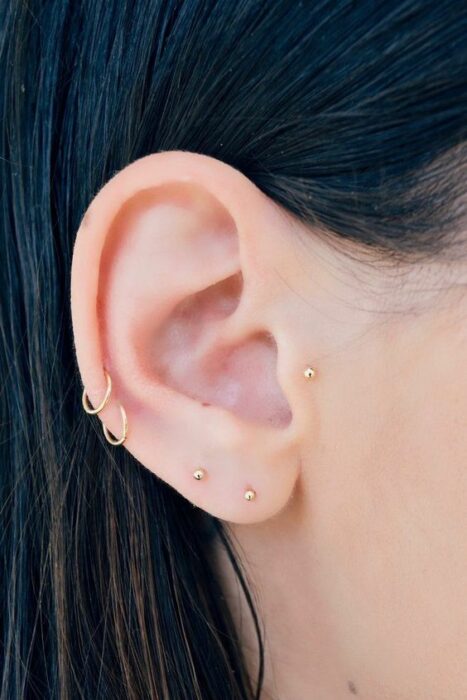 Chica con argollas y broqueles en el oído; 13 Creativas maneras de llevar más de un piercing en el oído