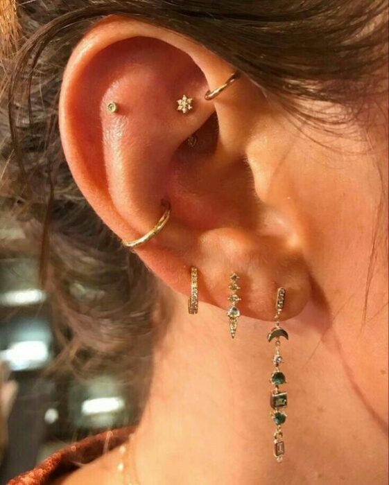 chica con multiples pendientes en el oído; 13 Creativas maneras de llevar más de un piercing en el oído