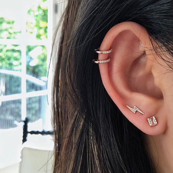 Chica con argollas y pendientes en forma de rayos; 13 Creativas maneras de llevar más de un piercing en el oído