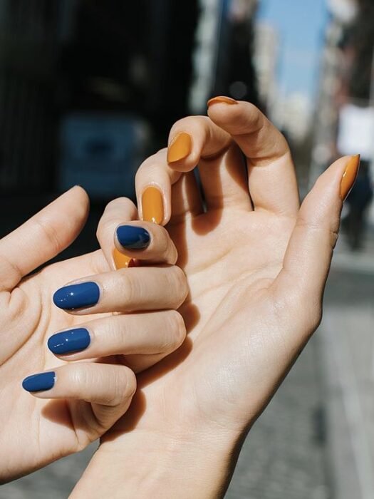 Chica con manicura de doble color en azul y mostaza; 19 Manicuras estilo arcoíris a las que no te podrás negar