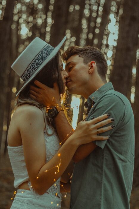 Pareja besándose en medio de un bosque