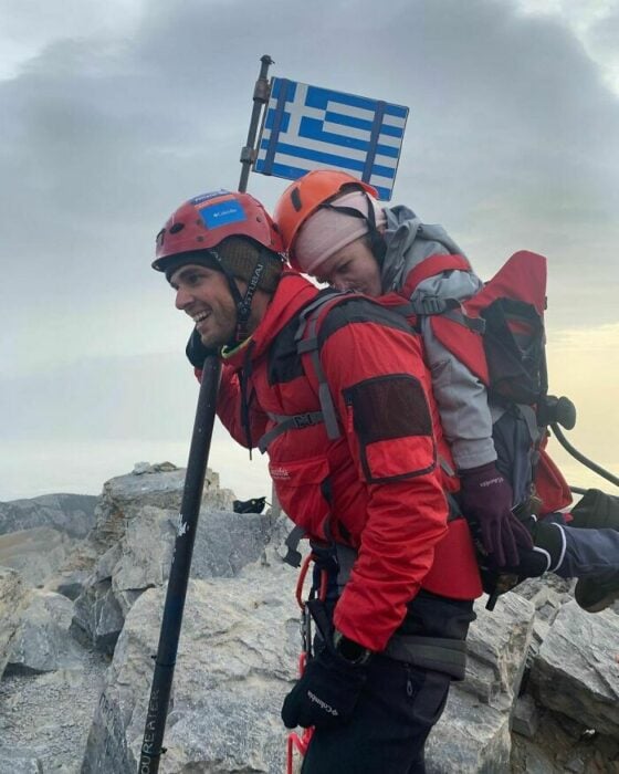 Alpinista cargando en la espalda a una chica con discapacidad movil