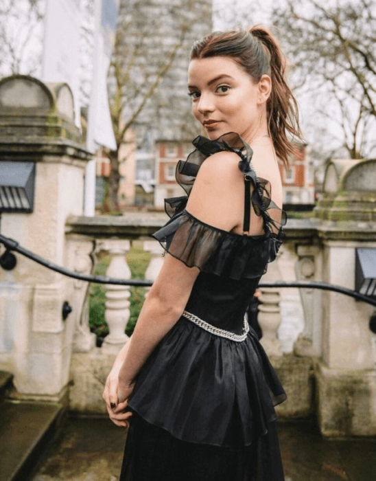 Anya Taylor-Joy usando un vestido negro con el cabello recogido