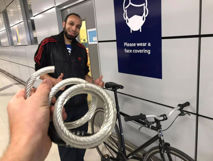 Fotografía de un joven al lado de su bicicleta