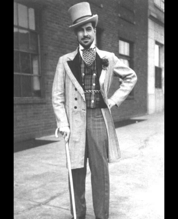 Foto vintage, fotografía antigua en blanco y negro de hombre con traje elegante, sombrero de copa, saco largo y bastón