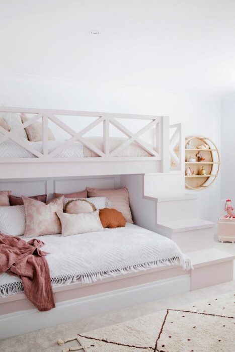 Habitación blanca con cama de dos pisos blanca y escalones para subir a la planta alta