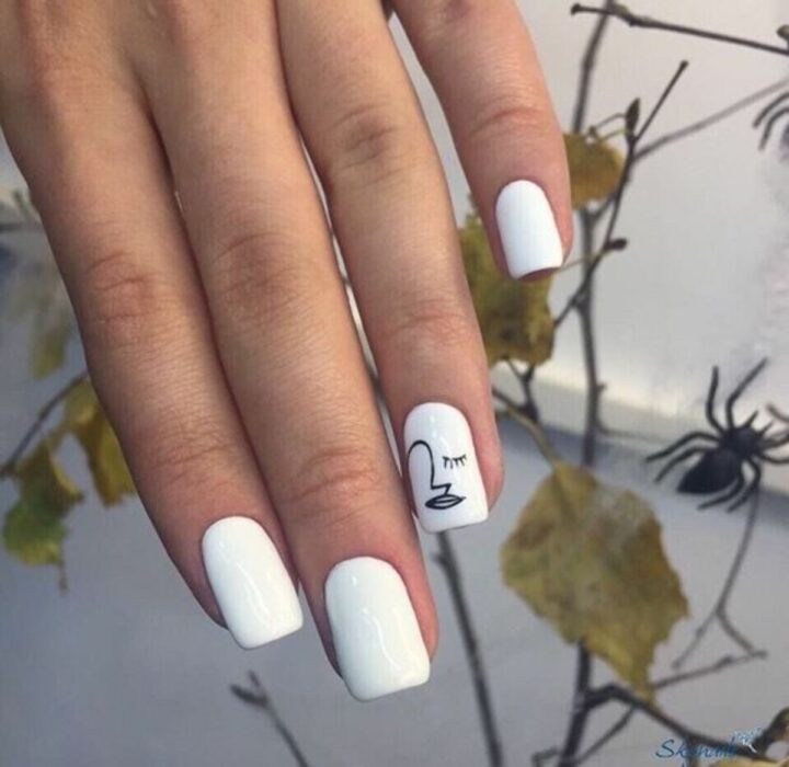 Chica con un diseño de uñas de color blanco con un toque de plateado y dorado