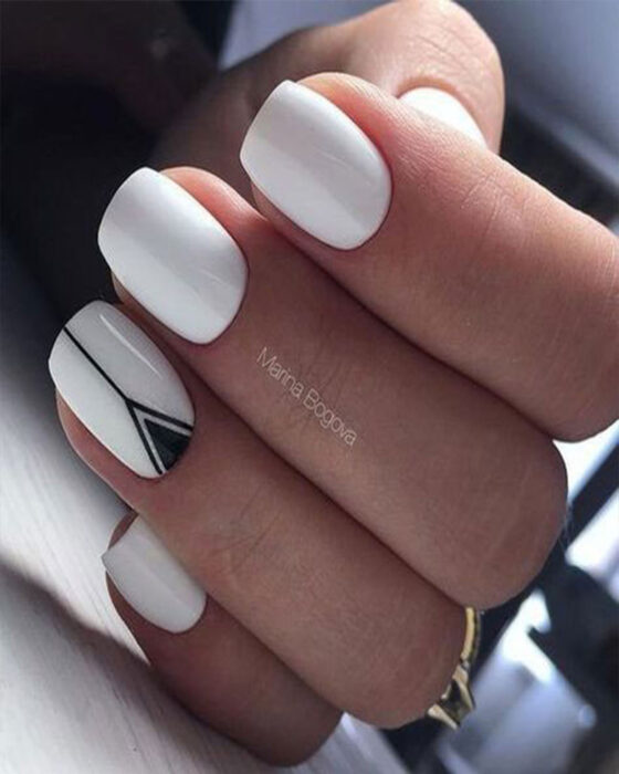 Chica con un diseño de uñas de color blanco con un toque de plateado y dorado