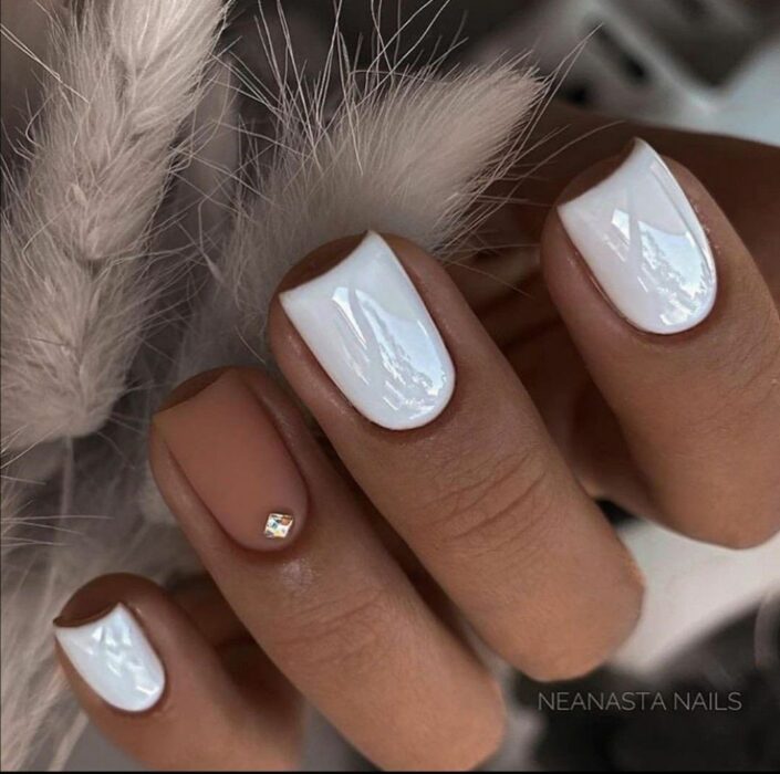 Chica con un diseño de uñas de color blanco con un toque de plateado y dorado