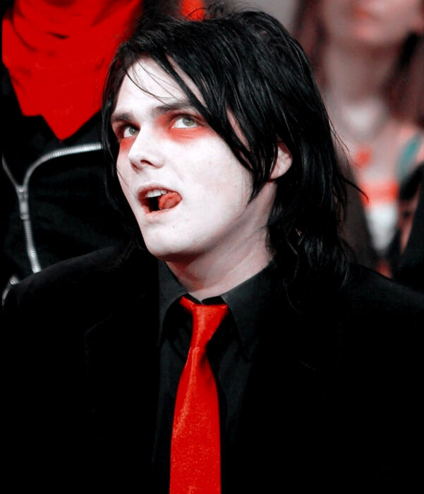 Gerard Way de My Chemical Romance, con cabello largo, negro, sombras de ojo rojas, traje negro, corbata roja, piel pálida