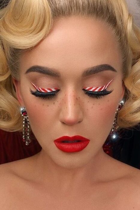 Katy Perry con maquillaje claro, labial rojo y delineado de caramelo; Maquillajes para celebrar Navidad