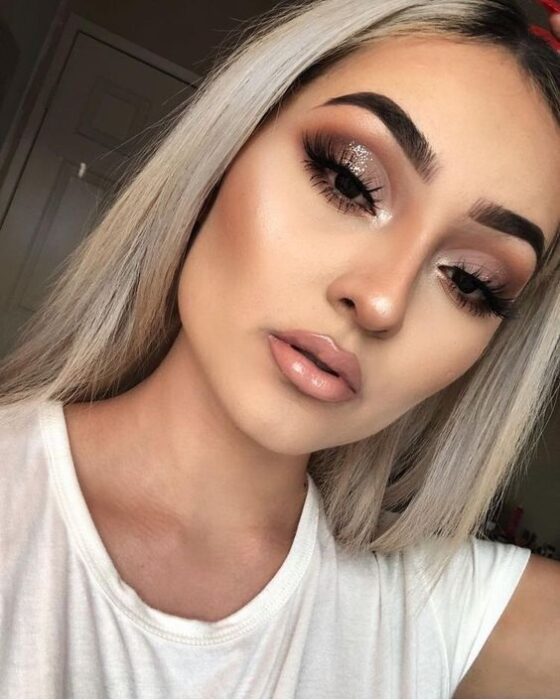 Chica con maquillaje en tonos dorados y labial nude; Maquillajes para celebrar Navidad