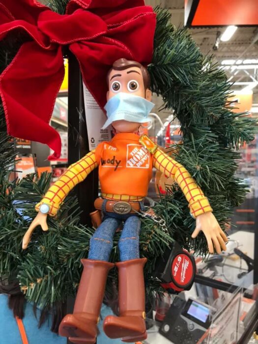 Muñeco de Woody sentado sobre una corona navideña; Niño se reencuentra con su muñeco Woody