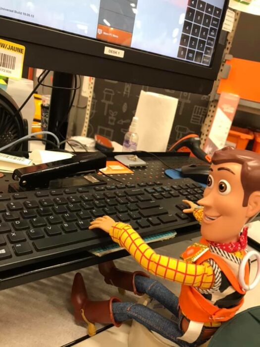 Muñeco Woody sentado frente a la computadora; Niño se reencuentra con su muñeco Woody