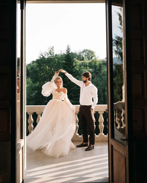 Pareja de novios el día de su boda bailando mientras están en una terraza 