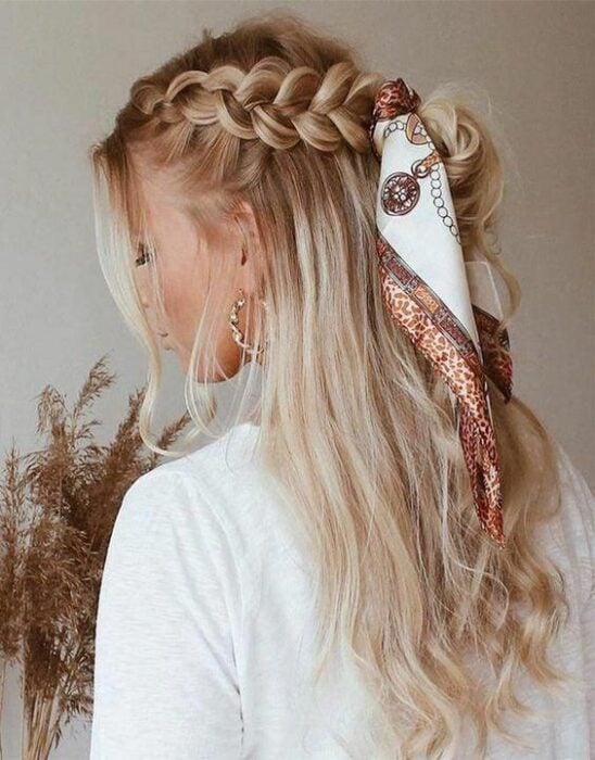 Chica de cabello rubio con medio recogido de trenzas y decorado de un pañuelo