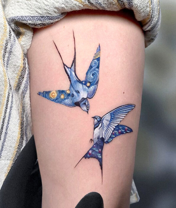 Tatuaje bonito y femenino de ave en el brazo, pájaros golondrinas volando fusionados con La noche estrellada de Vincent Van Gogh