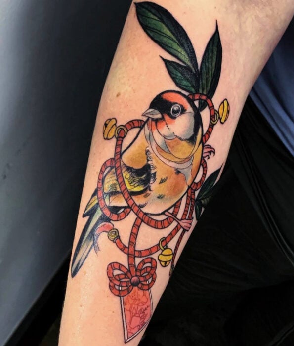 Tatuaje bonito y femenino de ave en el brazo, pájaro jilguero
