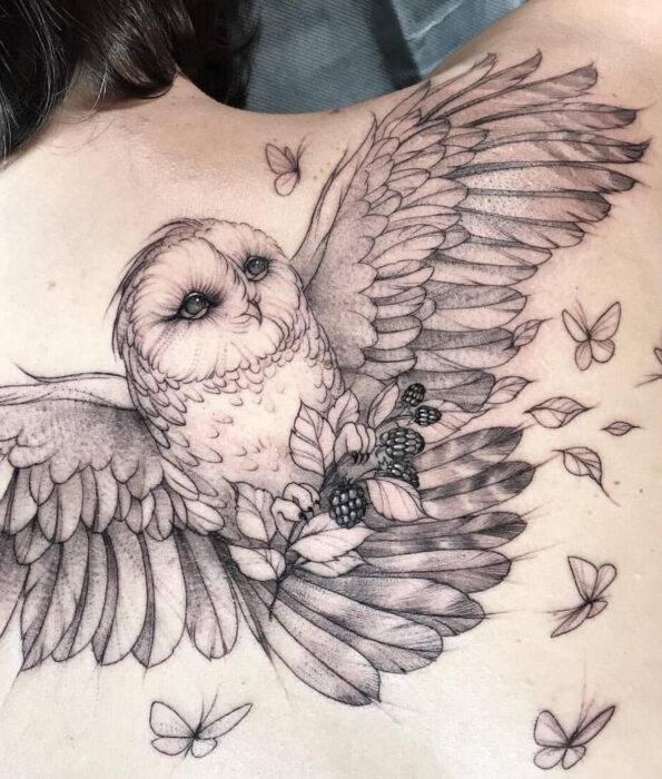 Tatuaje bonito y femenino de ave en la espalda, pájaro lechuza volando