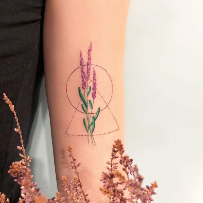 Tatuajes bonitos, pequeños y femeninos; tatuaje de espiga de lavanda con figuras geompetricas, círculo y triángulo en el brazo