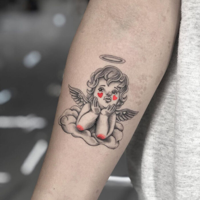 Tatuajes bonitos, pequeños y femeninos; tatuaje de querubín con corazones en los cachetes, en el brazo