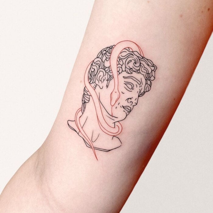 Tatuajes bonitos, pequeños y femeninos; tatuaje de busto de David de Miguel Ángel con serpiente en el brazo