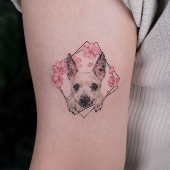 Tatuajes bonitos, pequeños y femeninos; tatuaje de perro con flores rosas en el brazo