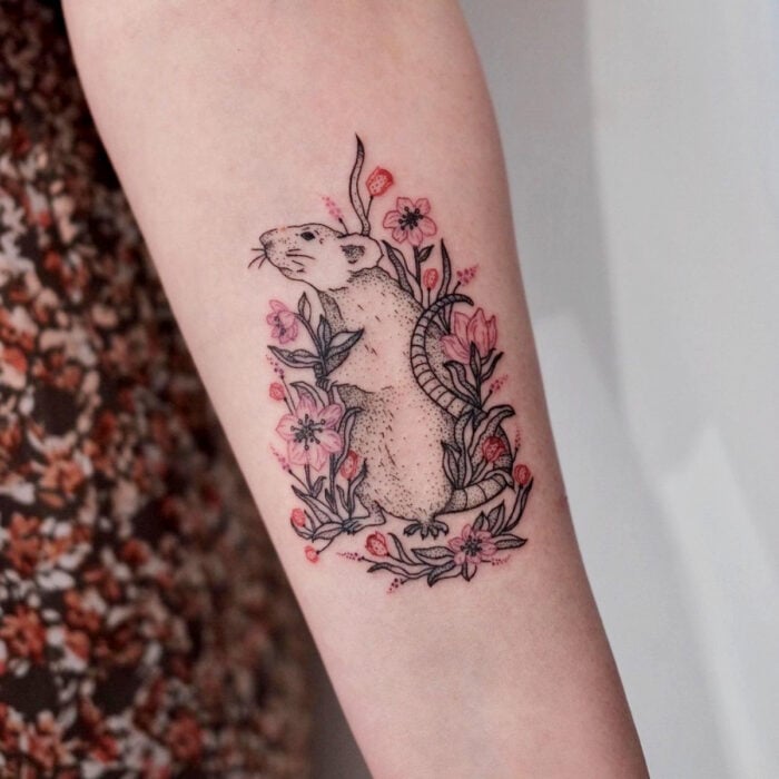 Tatuajes bonitos, pequeños y femeninos; tatuaje de ratón con flores rosas en el brazo