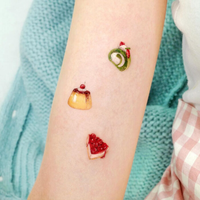 Tatuajes bonitos, pequeños y femeninos; tatuaje de postres minimalistas, flan, roll y pay en el brazo