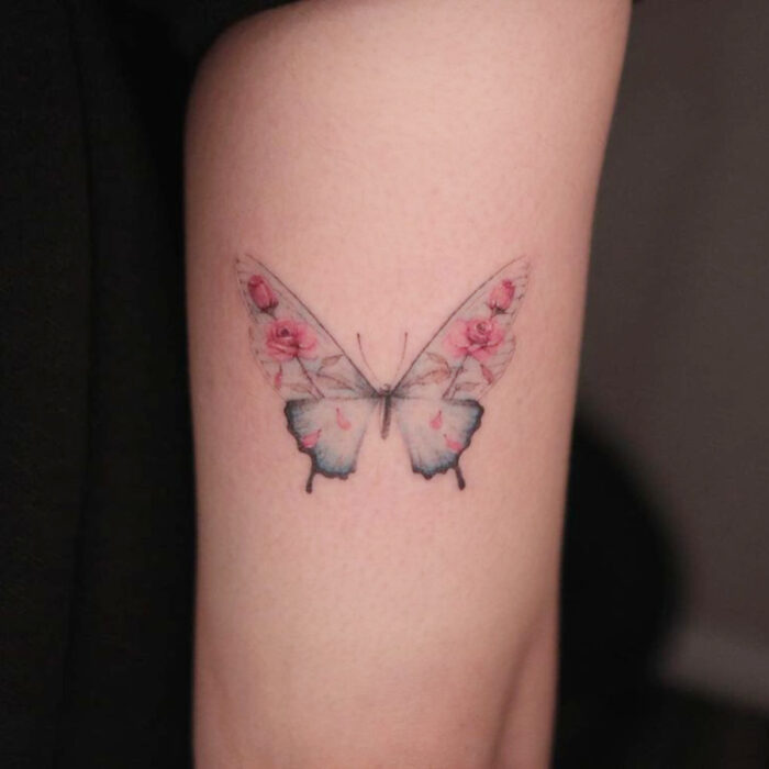 Tatuajes bonitos, pequeños y femeninos; tatuaje de mariposa con alas de flores rosas en el brazo