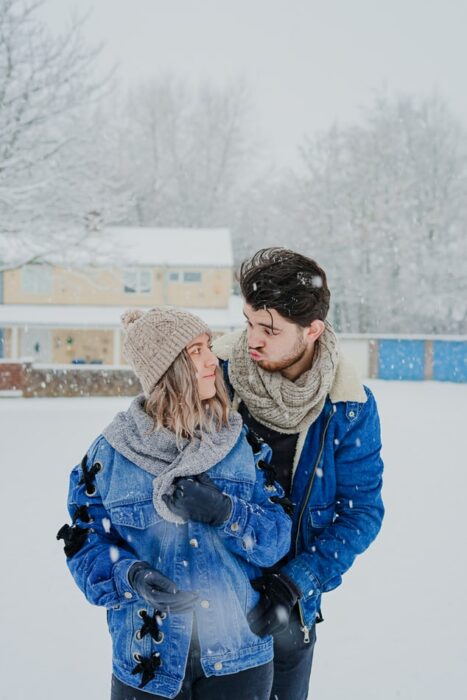 Pareja en el exterior un día nevado de invierno