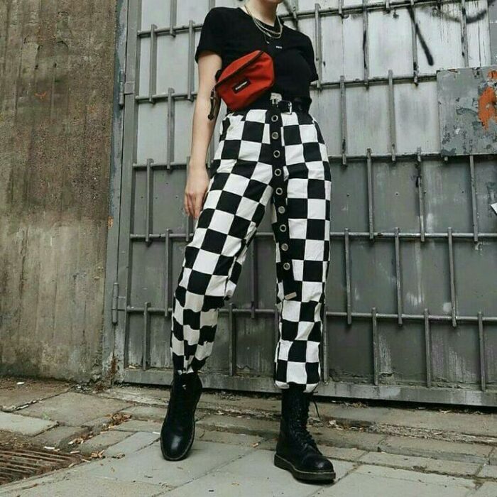 Chica con pantalones holgados a cuadros en color blanco y negro; 13 Ideas para usar pantalones holgados sin perder el estilo