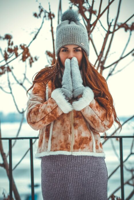 Chica usando prendas de invierno en un día nevado