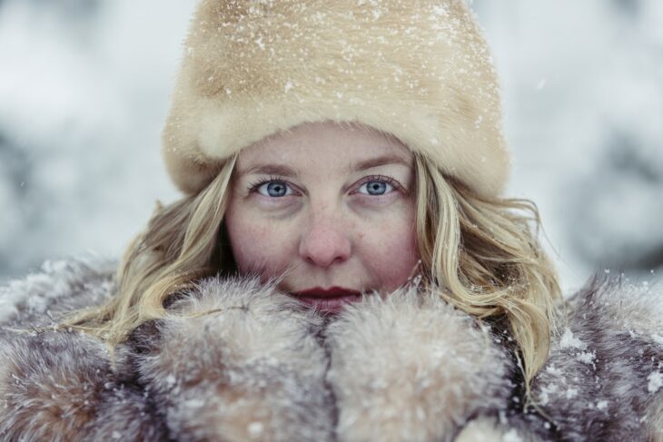 Mujer usando prendas de invierno en un día nevado