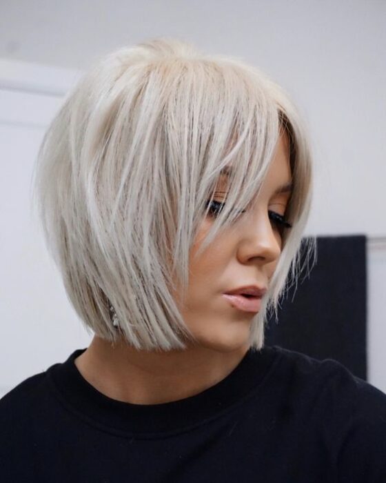 Mujer rubia de cabello platinado en melena muy corta degrafilada 