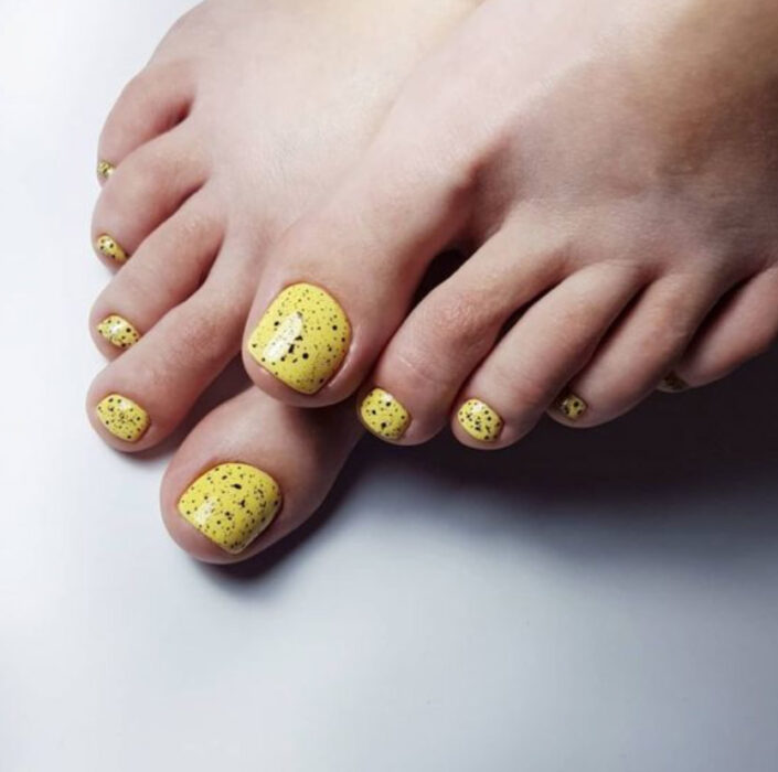 Pedicura en colores amarillo con detalles de puntos en color negro