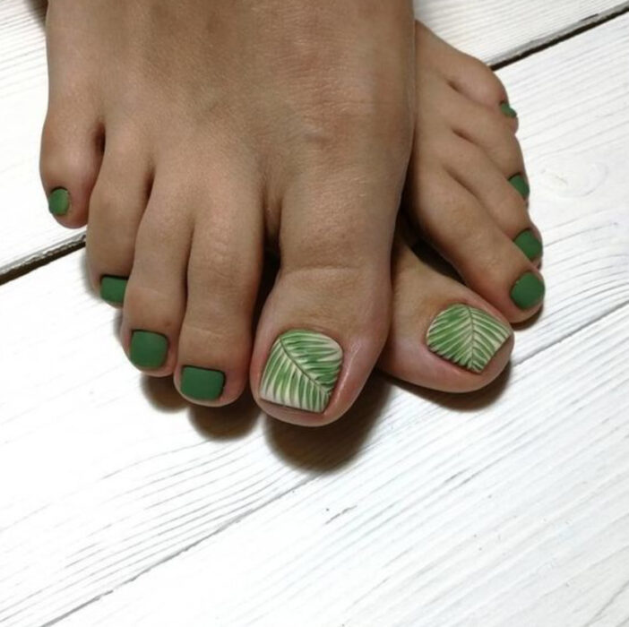 Pedicura en colores verde con detalles de hoja de palma